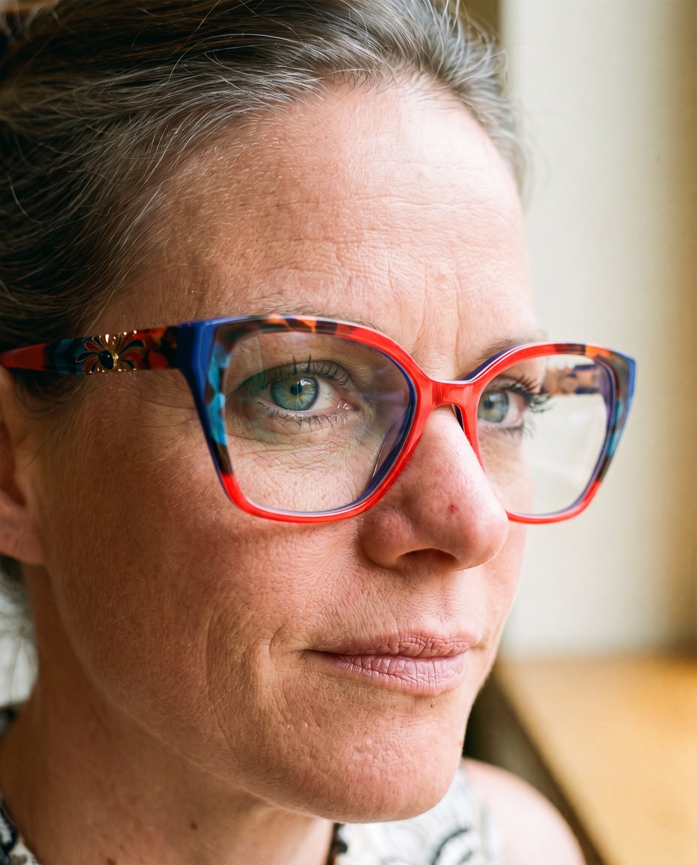 Frau mit blauer Brille hält eine Kaffeetasse