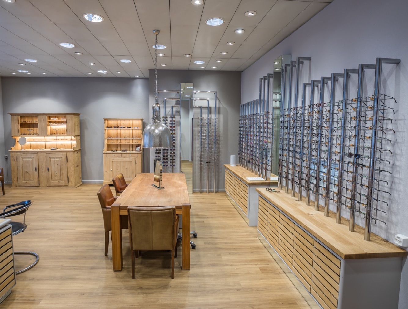 Der Showroom von CITYOPTIC in Dietikon: langer Eichentisch, Lederstühle, Wände voller Fassungen